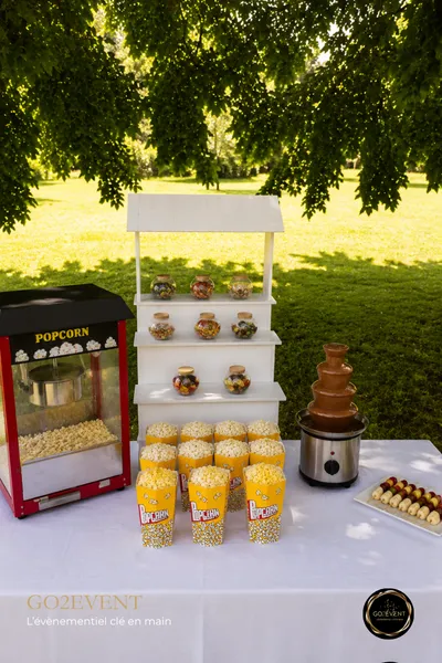 Présentation d'un kit gourmandise : machine à pop-corn, fontaine à chocolat et bonbons sur présentoir - Go2Event.